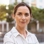 Portrait of happy mature businesswoman looking at camera. Successful proud woman in city street at sunset. Satisfied latin business woman in formal clothing smiling outdoors.